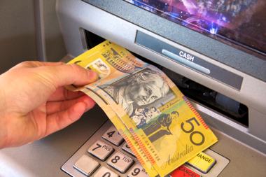 Photo of a person withdrawing money from an automatic teller machine