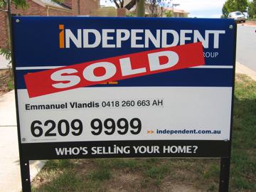 Photo of a real estate agents for sale sign outside a house