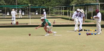 A photo of an elderly man playing lawn bowls