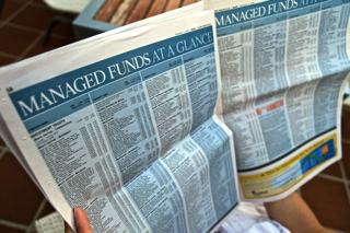 Photo of an open newspaper with multiple columns containing lists of the names of managed funds