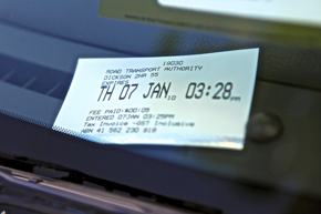 A photo of a parking ticket on the wind screen of a car