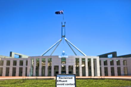 Photo of the front of Parliament House Canberra. There is a large fountain out the front of parly that’s filled with recycled water which has been completely cut out of the foreground of this photo. But included in the photo is the top of a sign placed within the fountain that reads “Recycled effluent, avoid contact.”