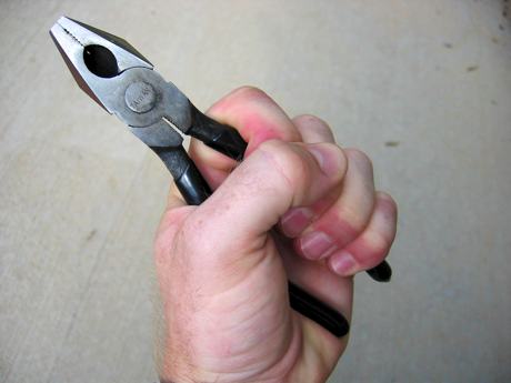 Photo of a hand holding a pair of pliers