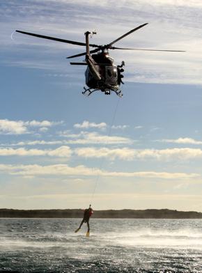 A photo of a rescue helicopter pulling a person from the water