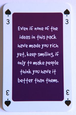 Playing card three of spades reads: Even if none of the ideas in this pack have made you rich yet, keep smiling, if only to make people think you have it better than them.