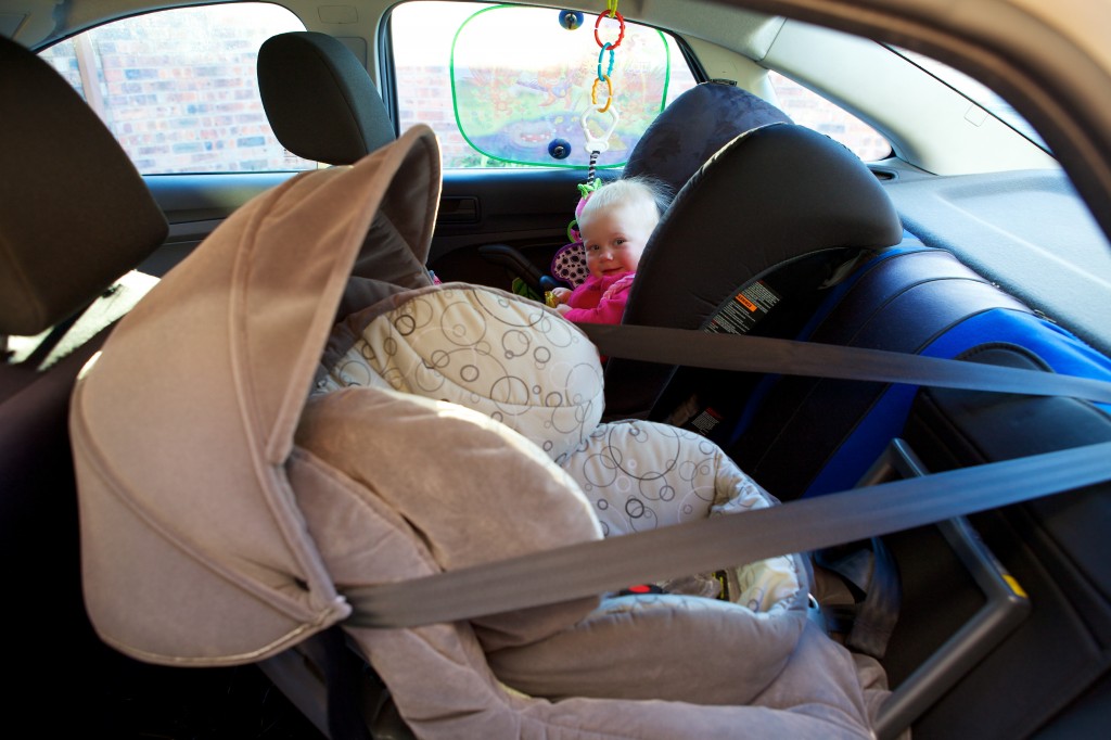 Photo of the back seat of a car with 2 baby seats.